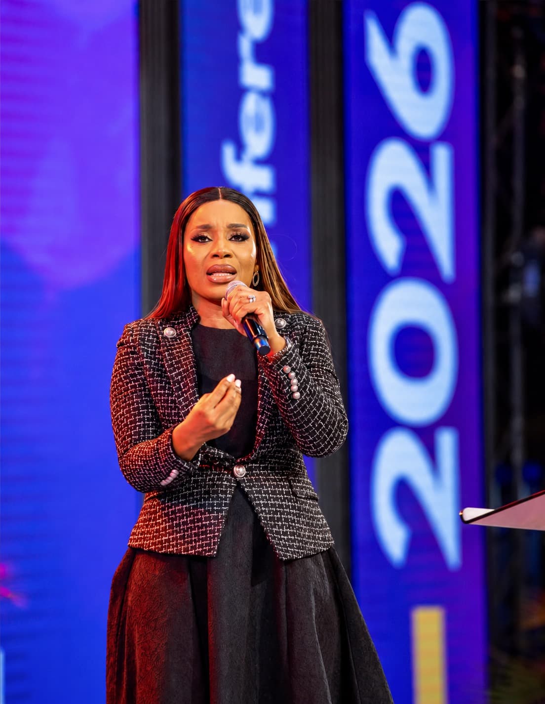 A woman leader speaking into a microphone during a public service panel